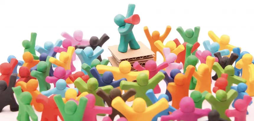 Viele bunte Knetmännchen in verschiedenen Farben und Posen auf weißem Hintergrund