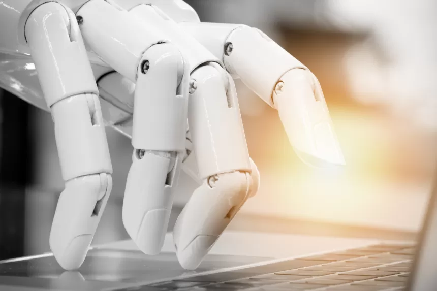 Einer Roboter-Hand tippt auf einem Laptop