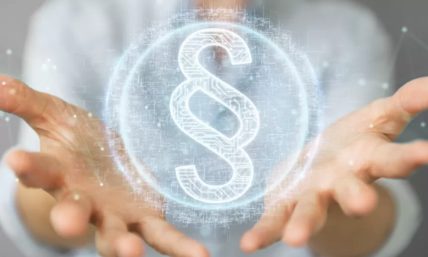 Hände halten ein leuchtendes Paragraphen-Symbol als Zeichen für Recht und Gesetz