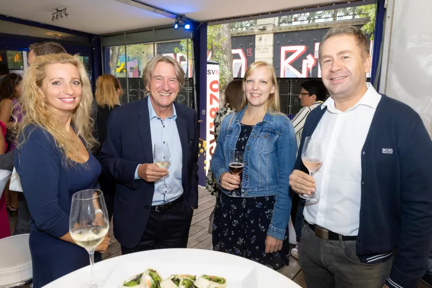 Vier Personen stehen um einen Stehtisch mit kleinen Häppchen und halten Getränke beim Sommerausklang des KSV1870