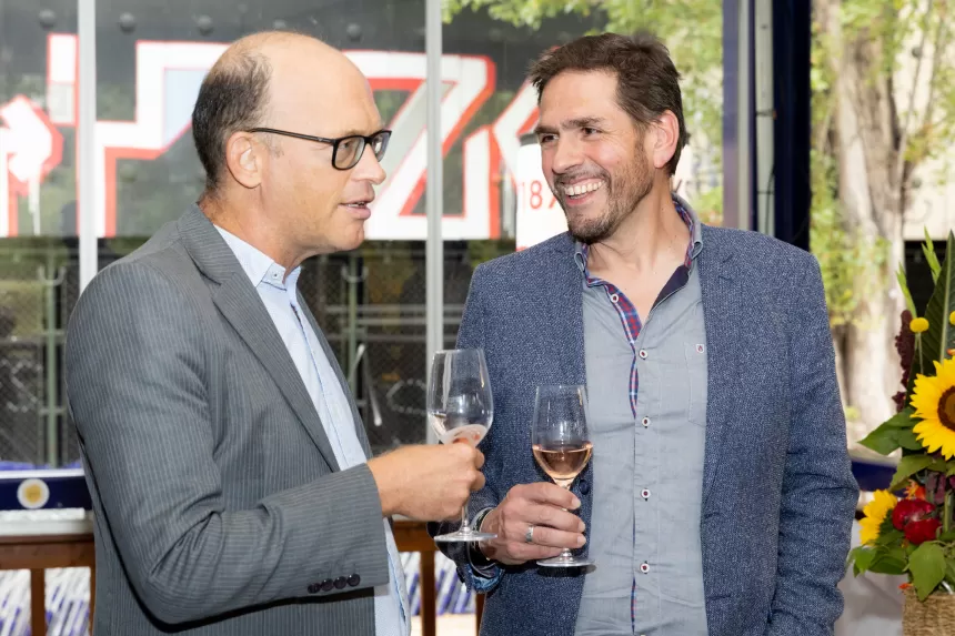 Zwei Männer in Anzügen unterhalten sich bei einem Glas Wein beim Sommerausklang des KSV1870