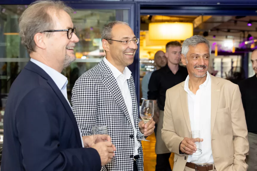 Drei Männer in Anzügen unterhalten sich bei Sommerausklang des KSV1870, halten Getränke in der Hand