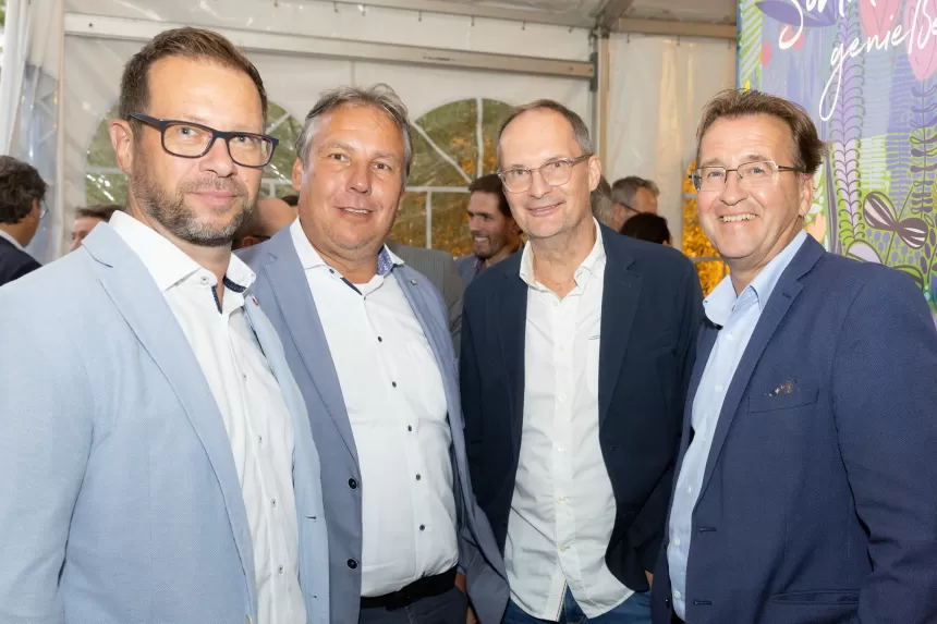 Vier Männer in Anzügen stehen zusammen beim Sommerausklang des KSV1870 in einem Zelt