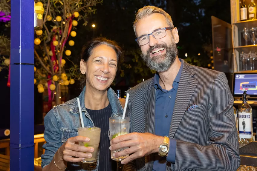 Zwei Personen beim Sommerausklang des KSV1870, die Getränke in der Hand halten, eine trägt Jeansjacke, die andere Anzug mit blauem Hemd