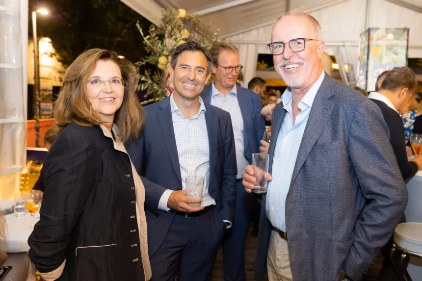 Drei Personen in eleganter Kleidung unterhalten sich bei der Sommerausklang-Veranstaltung des KSV1870, zwei Männer tragen Anzüge, eine Frau trägt eine Jacke