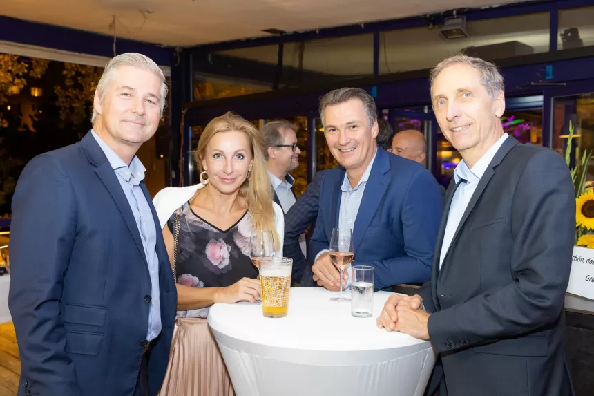 Vier Personen stehen um einen Stehtisch mit Getränken beim Sommerausklang des KSV1870 in einem Zelt mit anderen Gästen im Hintergrund