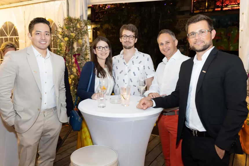 Fünf Personen stehen um einen Stehtisch mit weißen Tischdecke, halten Getränke beim Sommerausklang des KSV1870