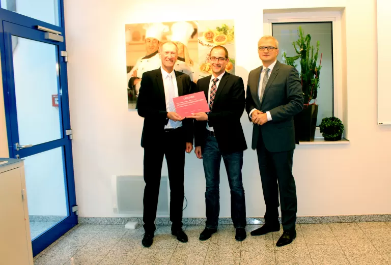 Die beiden KSV1870 Geschäftsführer Johannes Nejedlik (li.) und Mag. Ricardo-José Vybiral, MBA (re.) überreichen dem Geschäftsführer Mag. Andreas Kirchner die Jubiläumsurkunde.