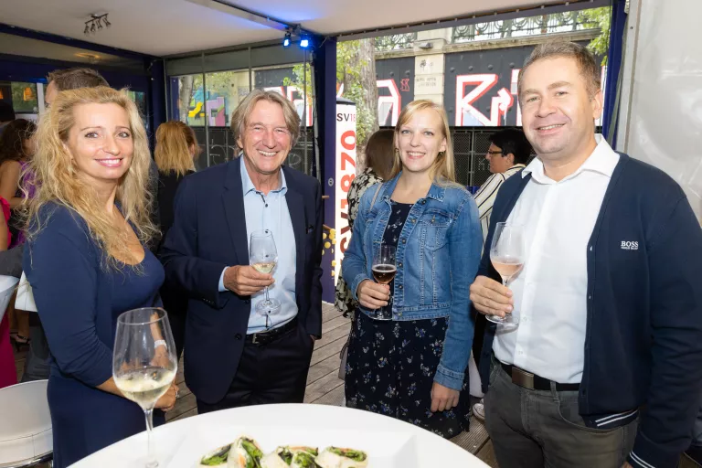 Vier Personen stehen um einen Stehtisch mit kleinen Häppchen und halten Getränke beim Sommerausklang des KSV1870