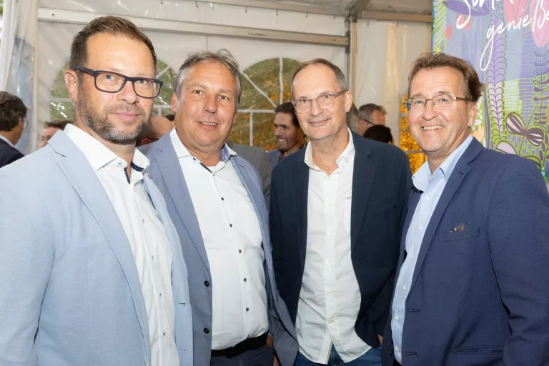 Vier Männer in Anzügen stehen zusammen beim Sommerausklang des KSV1870 in einem Zelt