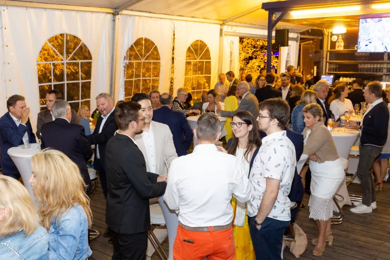 Viele Personen stehen in einem Festzelt beim Sommerausklang des KSV1870, unterhalten sich, im Hintergrund ist eine Bar