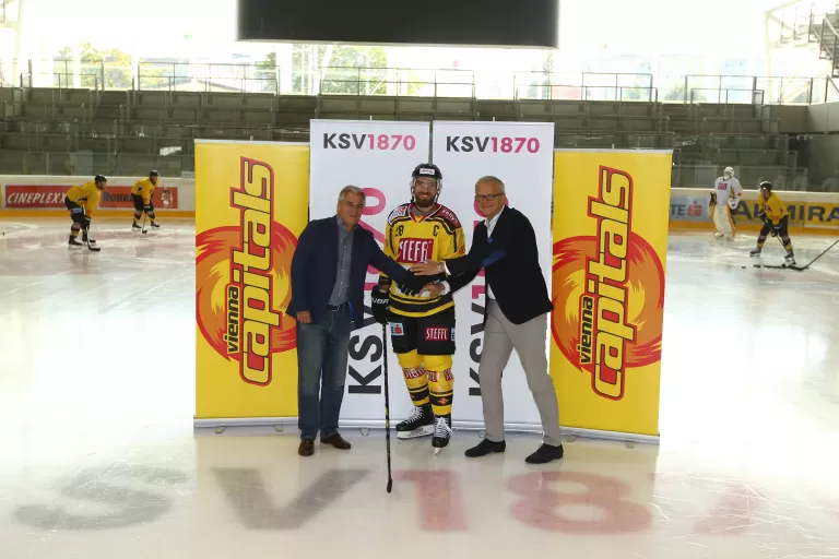Ricardo-José Vybiral postiert mit Eishokeyspieler von Vienna Capitals auf dem Eis.