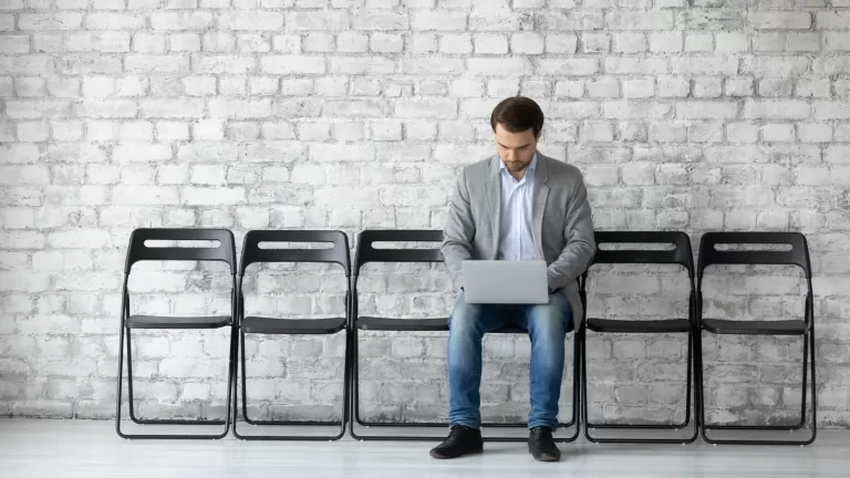 Ein Bewerber sitzt auf einer leeren Stuhlreihe