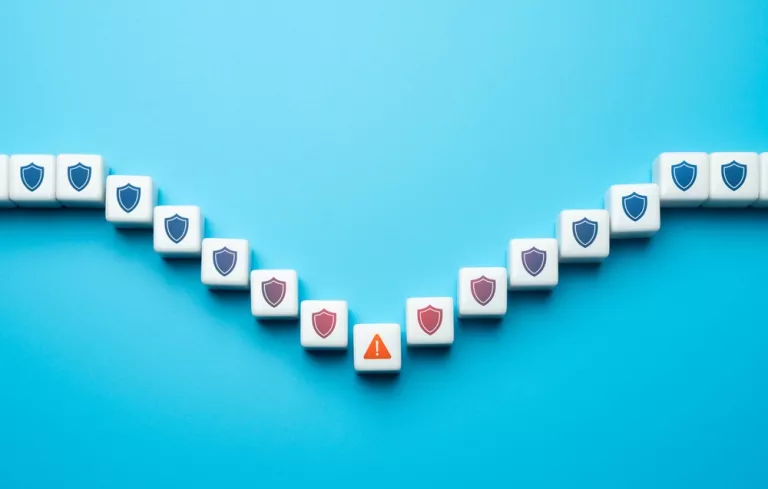 Weiße Steinchen mit Cybersicherheit-relevanten Icons auf blauen Hintergrund