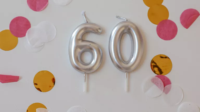 Geburtstagskerzen in den Zahlen 6 und 0 mit pinkem Konfetti