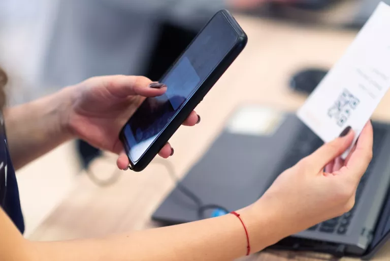 Dame scannt QR-Code mit ihrem Handy.