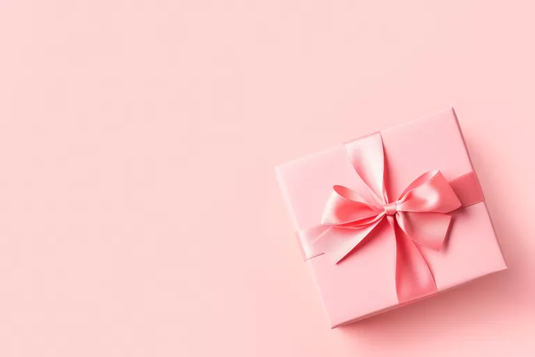 rosafarbene Geschenkbox auf rosafarbenem Hintergrund