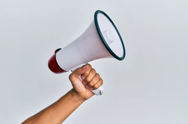 Hand hält weißes Megaphone