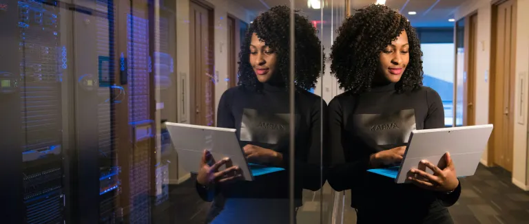 Frau mit Laptop vor Serverraum