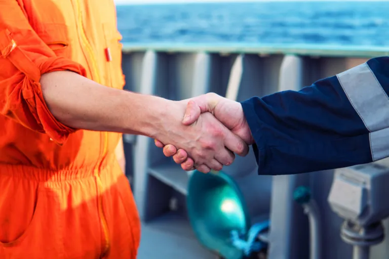 Geschäftlicher Handschlag auf einem Schiff