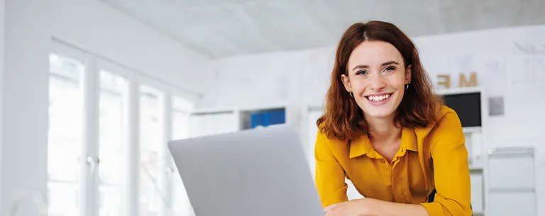 Jungunternehmerin sitzt vor ihrem Laptop