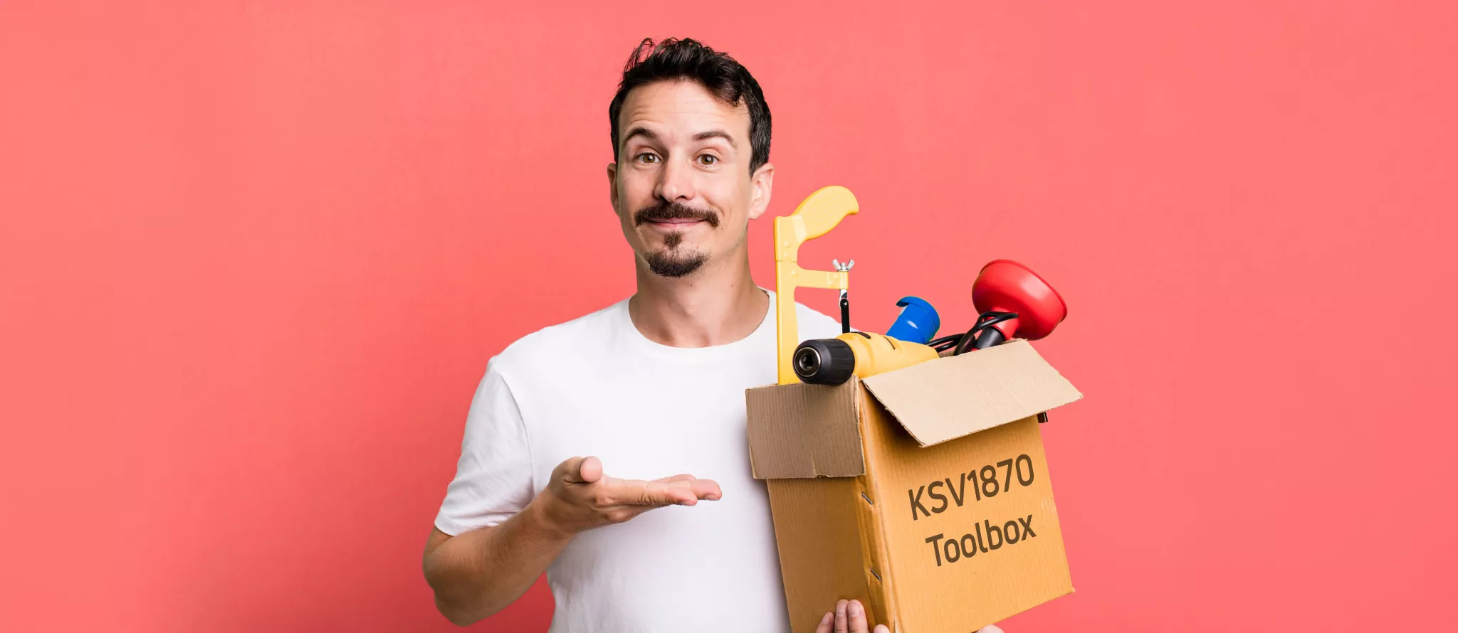 Mann in weißem T-Shirt und mit Bart. Er hat eine Kiste mit Werkzeugen in der linken Hand hat. Auf der Kiste steht "KSV1870 Toolbox". Er deutet mit der rehcten Hand auf die Kiste und lächelt. Der Hintergrund ist rosa. 