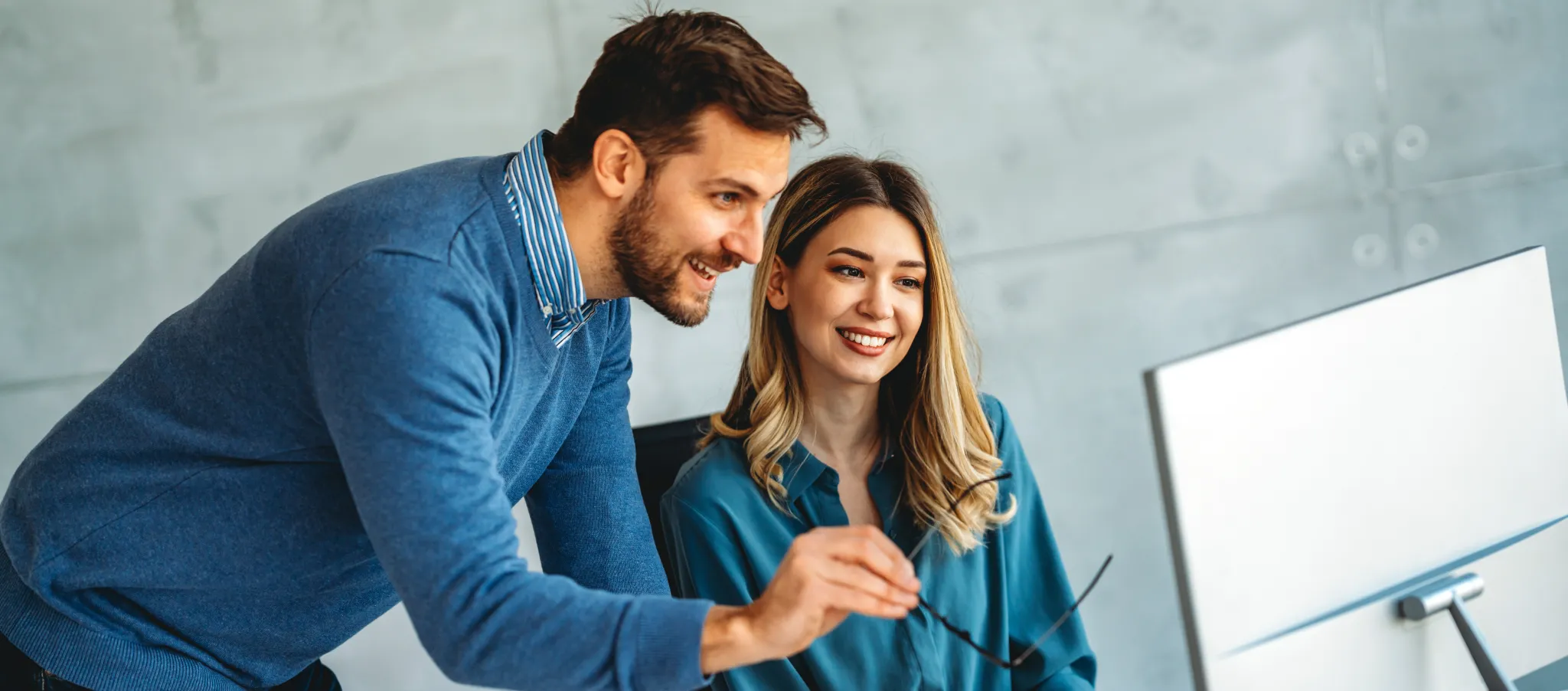 Zwei Steuerberater Kollegen analysieren ein Dokument am Laptop